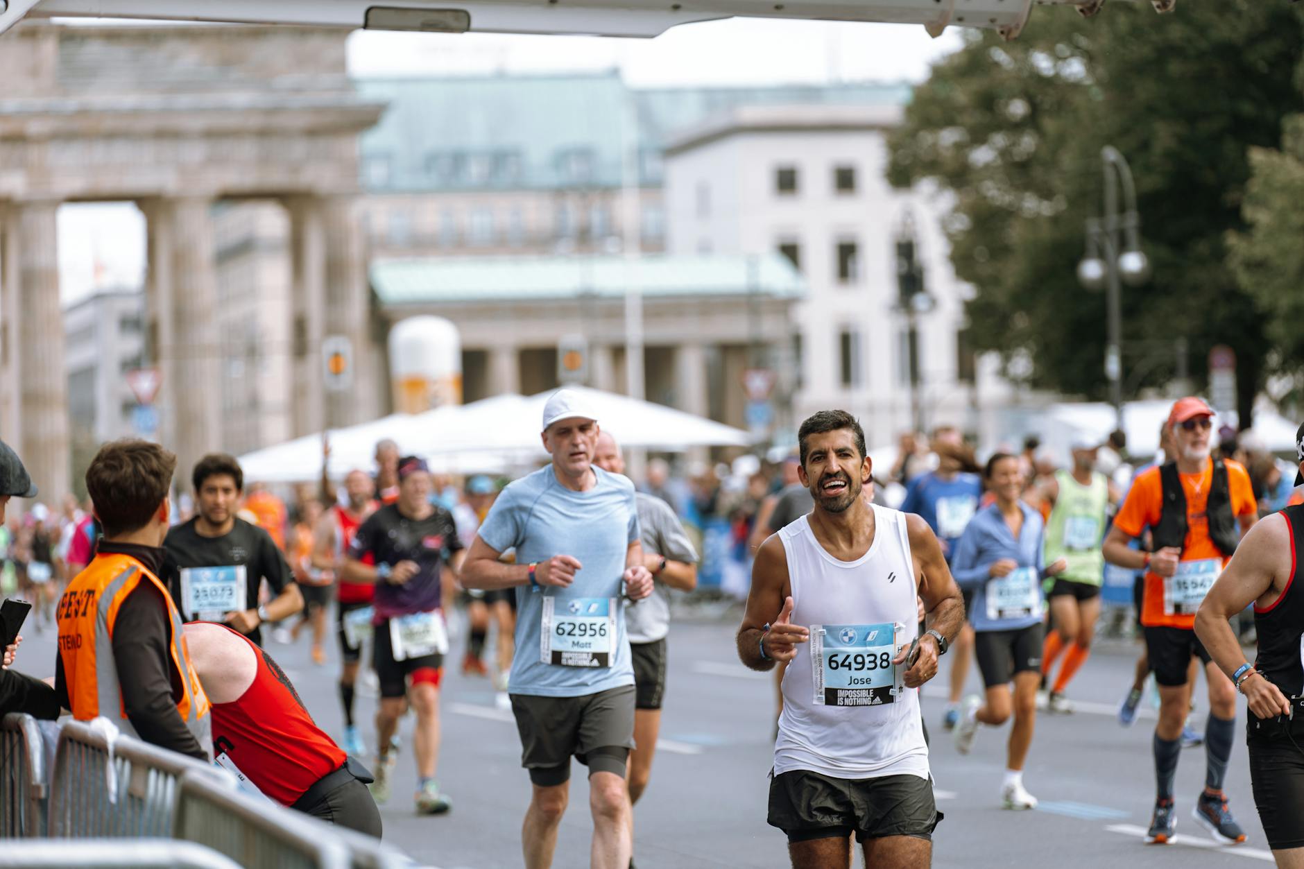 Runners crossing a marathon finish line under cheering crowds