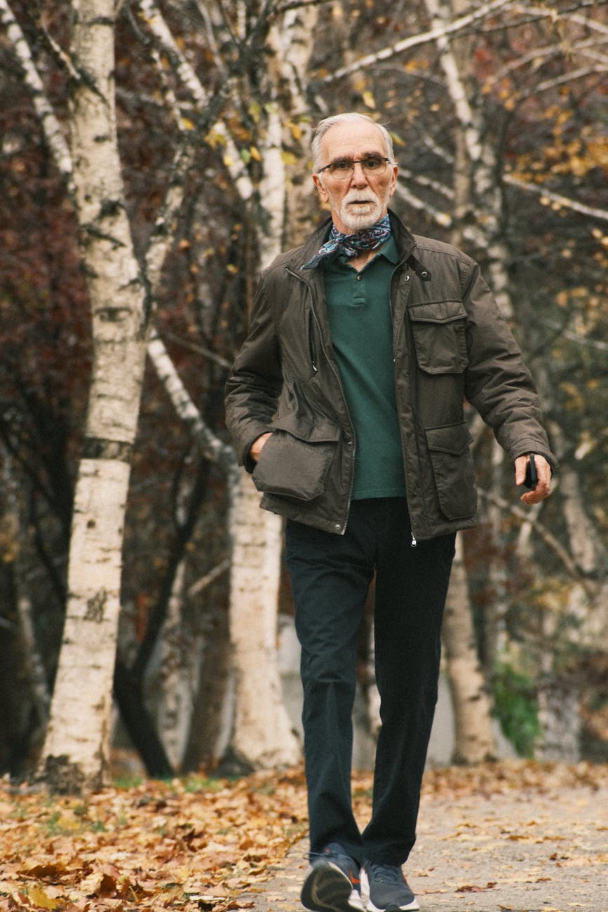 Senior man walking alone along a forest pathway, capturing the everyday gait that the Apple-Michigan cohort study tracked.