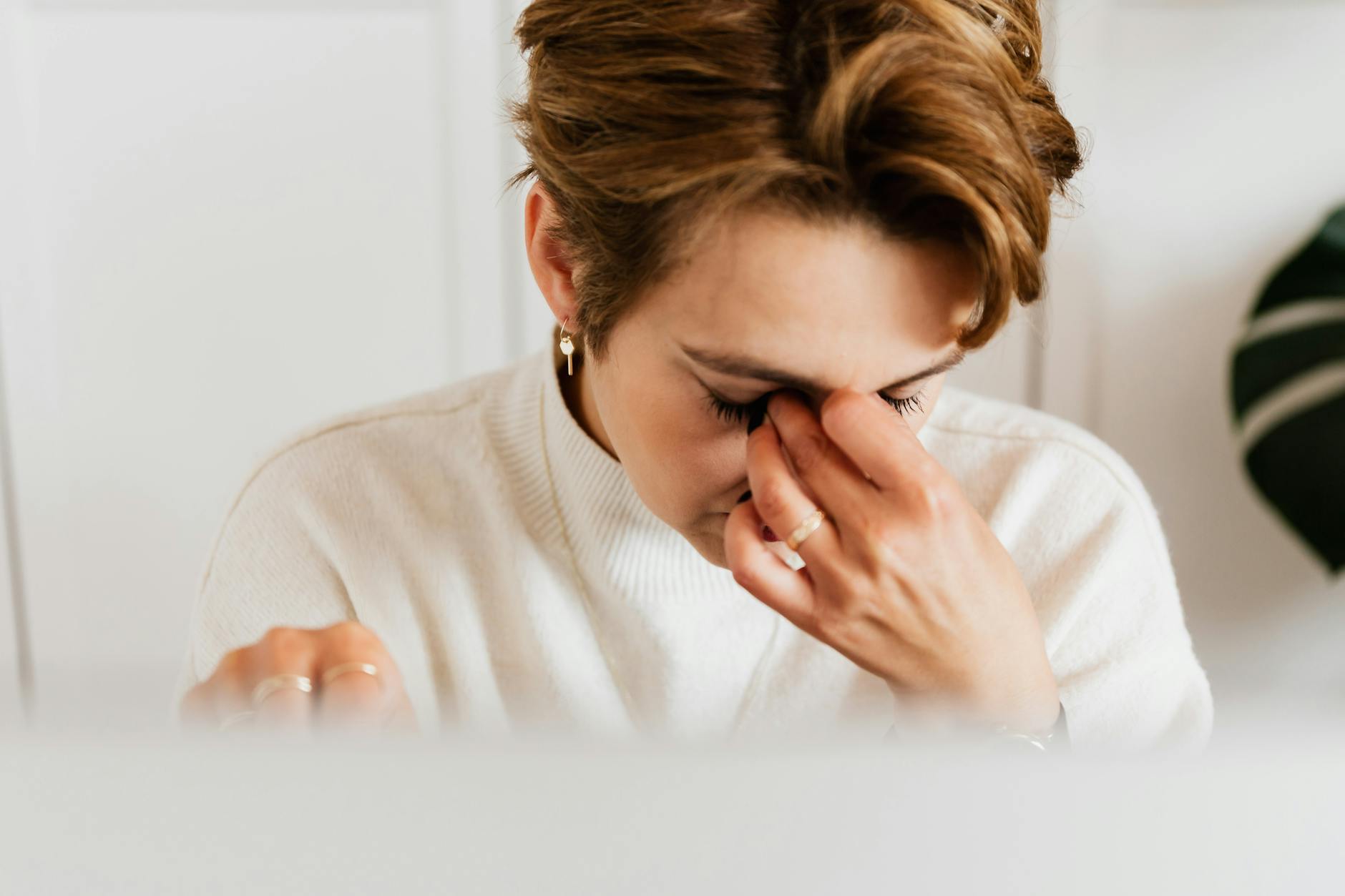 Close-up of a woman rubbing her eyes, conveying fatigue and eye strain