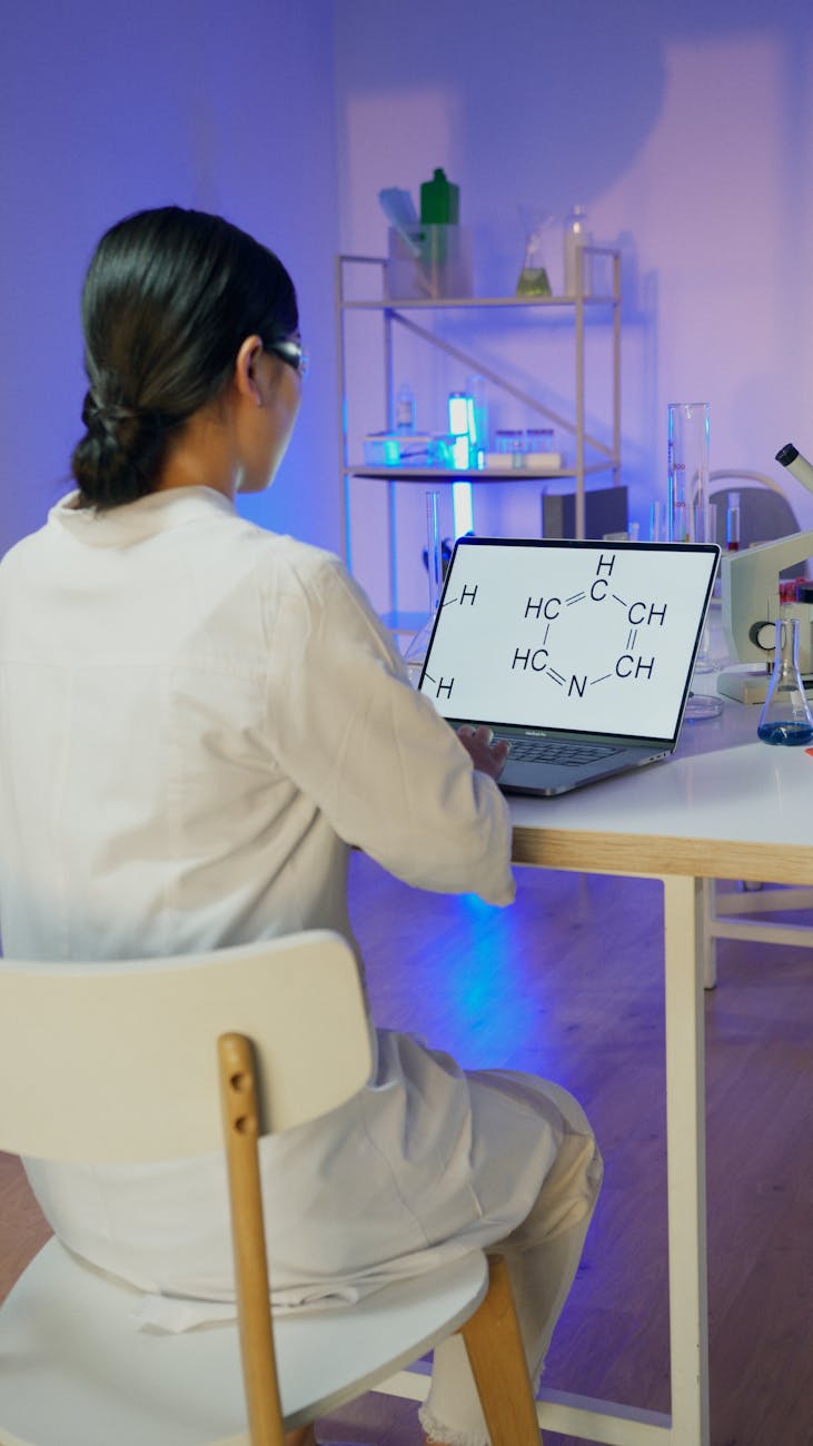A researcher examining chemical diagrams on a laptop in a laboratory, echoing the study's AI-assisted analysis of GLP-1 side effects.