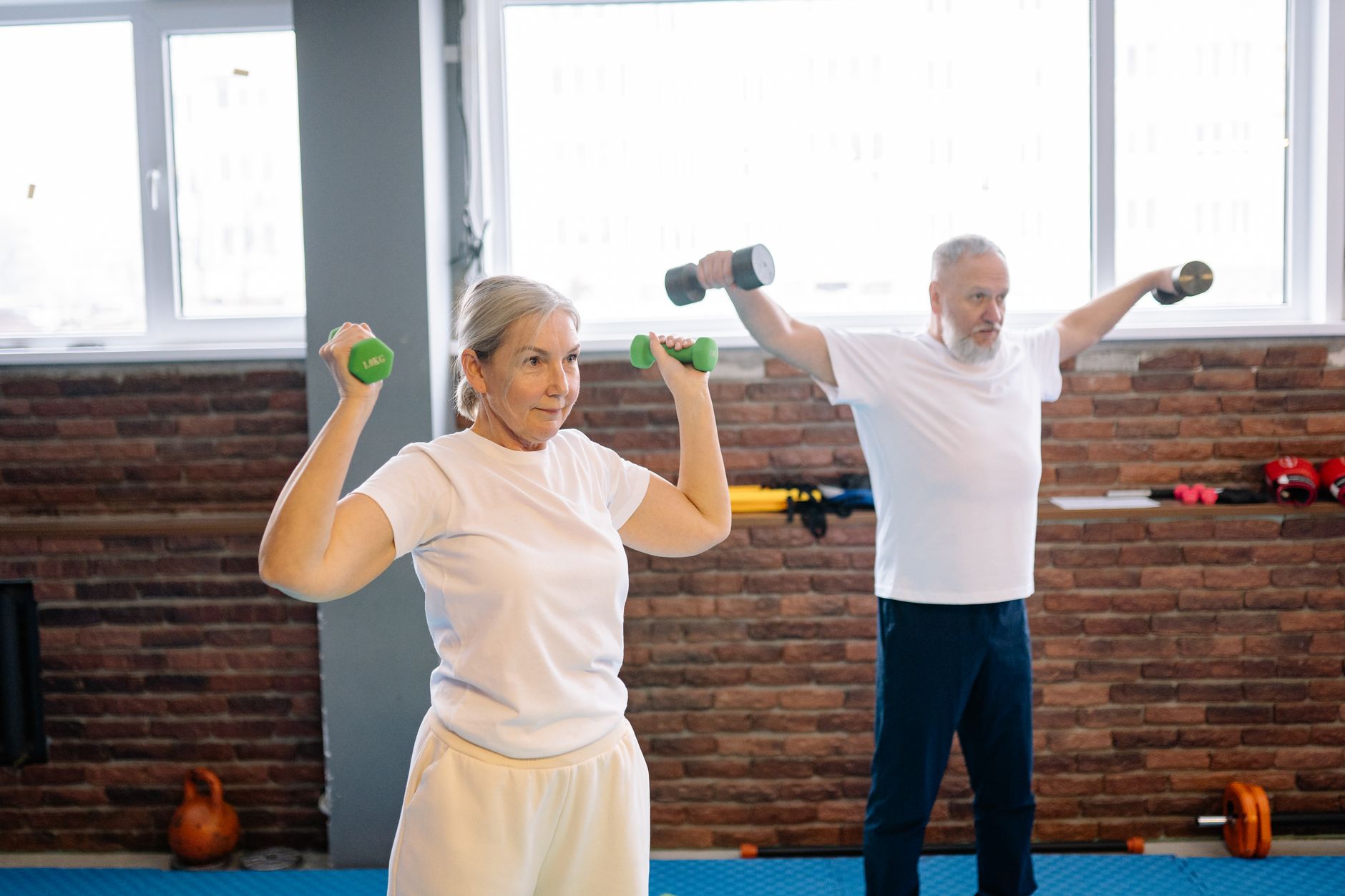 Older adults lifting dumbbells during a supervised gym session